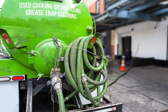 a technician pumping a grease trap in a commercial building in New Berlin